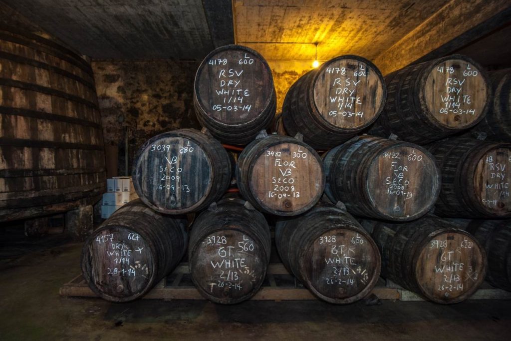 Several barrels of Sherry are maturing in a cellar, they are stacked on top of one another in a trapezium formation, with the oldest wines at the base.